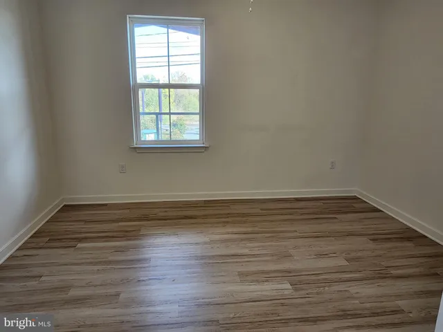 a view of a room with wooden floor and window