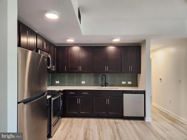 a kitchen with a sink stainless steel appliances and cabinets