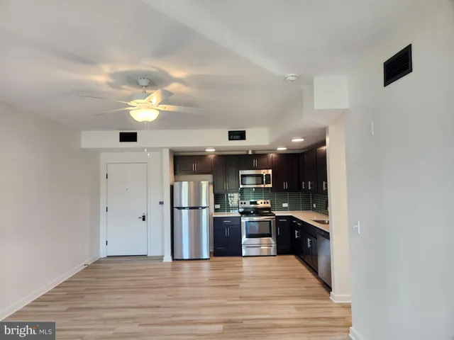 a large kitchen with stainless steel appliances granite countertop a stove and a refrigerator
