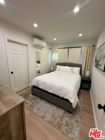 a bedroom with a bed and a refrigerator