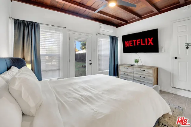 a bedroom with a bed and a flat screen tv