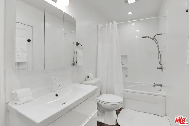 a bathroom with a white bath tub a toilet and a sink