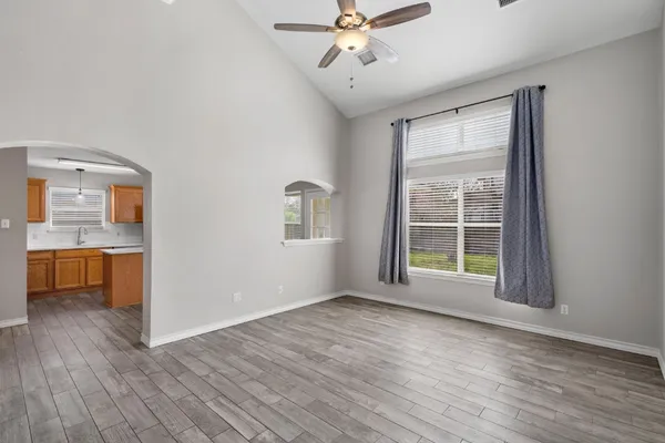 a view of an empty room with a window and wooden floor