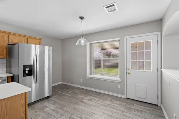 a view of an empty room with window and wooden floor