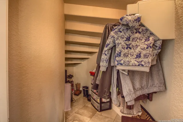 a spacious bedroom with a large bed a chandelier and windows