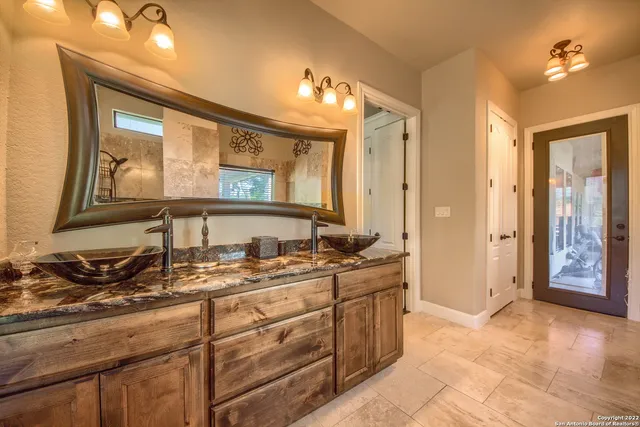 a bathroom with a granite countertop sink and a mirror