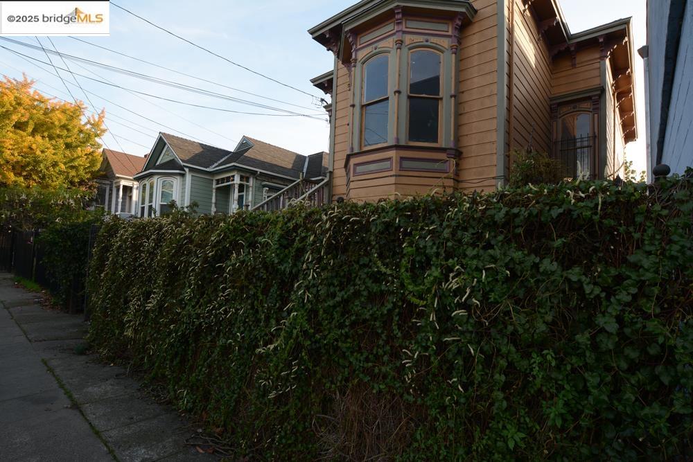 1633 8th Street Oakland, CA 94607 - Photo 43 of 56 a view of a house with brick walls and plants next to a road