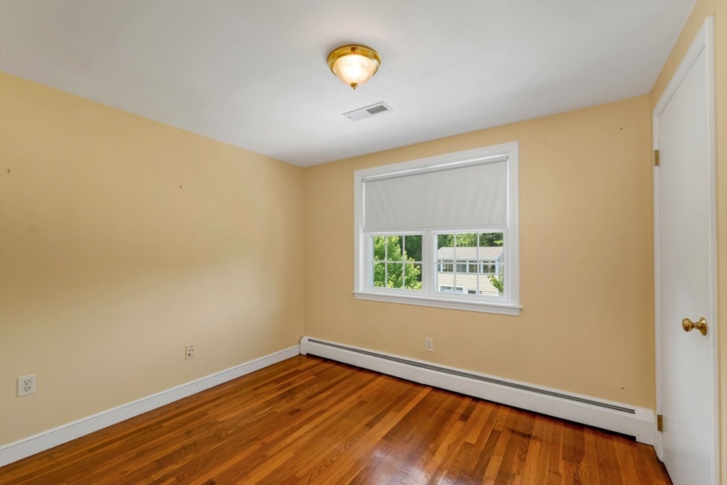 252 Littlefield Road Boxborough, MA 01719 - Photo 24 of 40 a view of an empty room with window and wooden floor