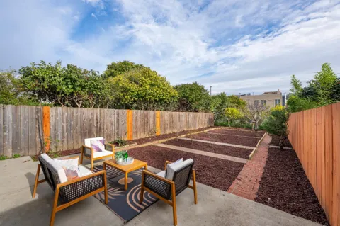 an outdoor sitting area with furniture and wooden fence