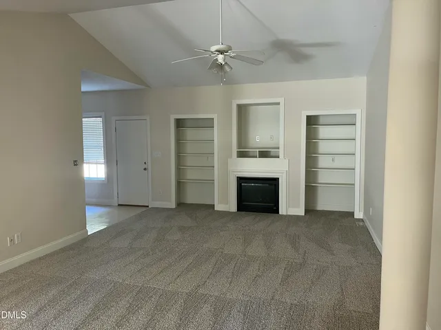 an empty room with a ceiling fan closet and windows