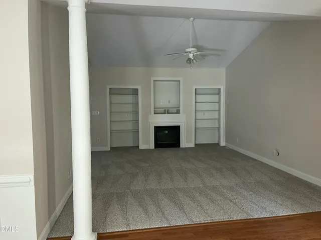 an empty room with a fireplace and a chandelier