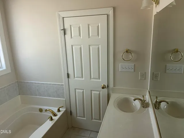 a bathroom with a tub a sink and a shower