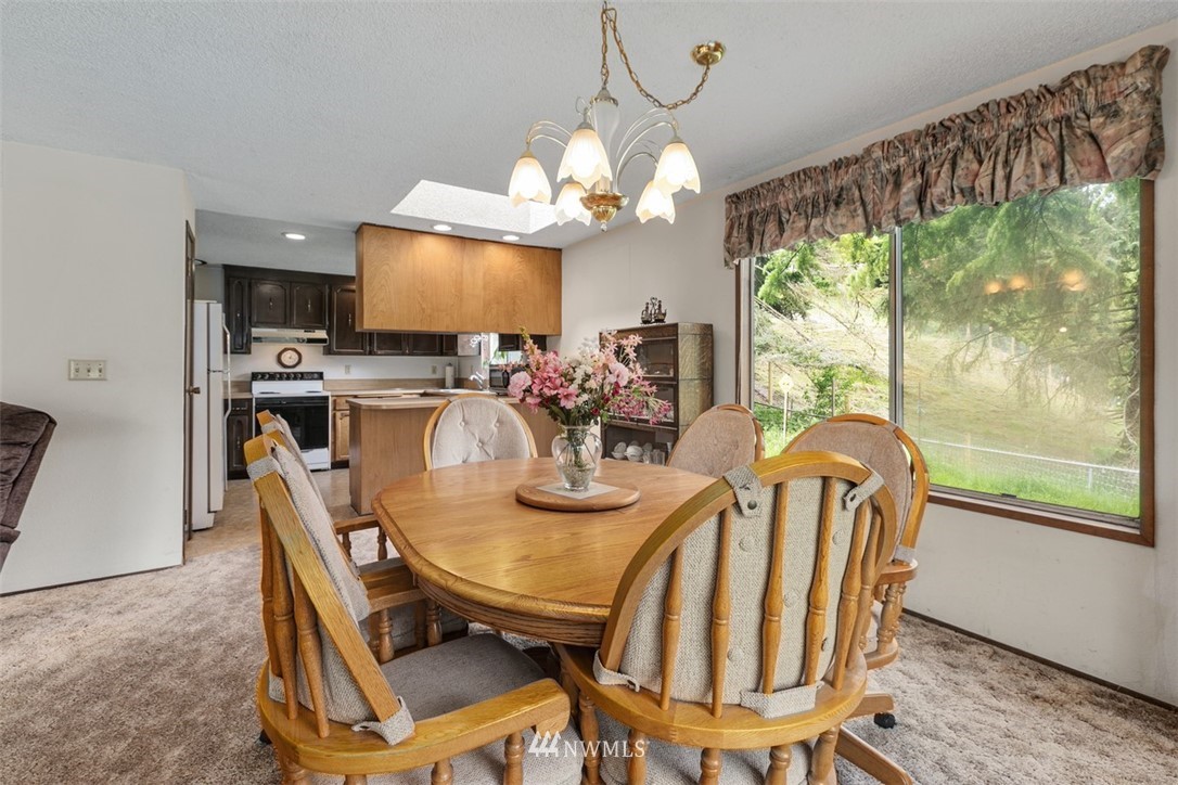 23525 27th Avenue Southeast Bothell, WA 98021 - Photo 6 of 40 a view of a dining room with furniture a chandelier and wooden floor