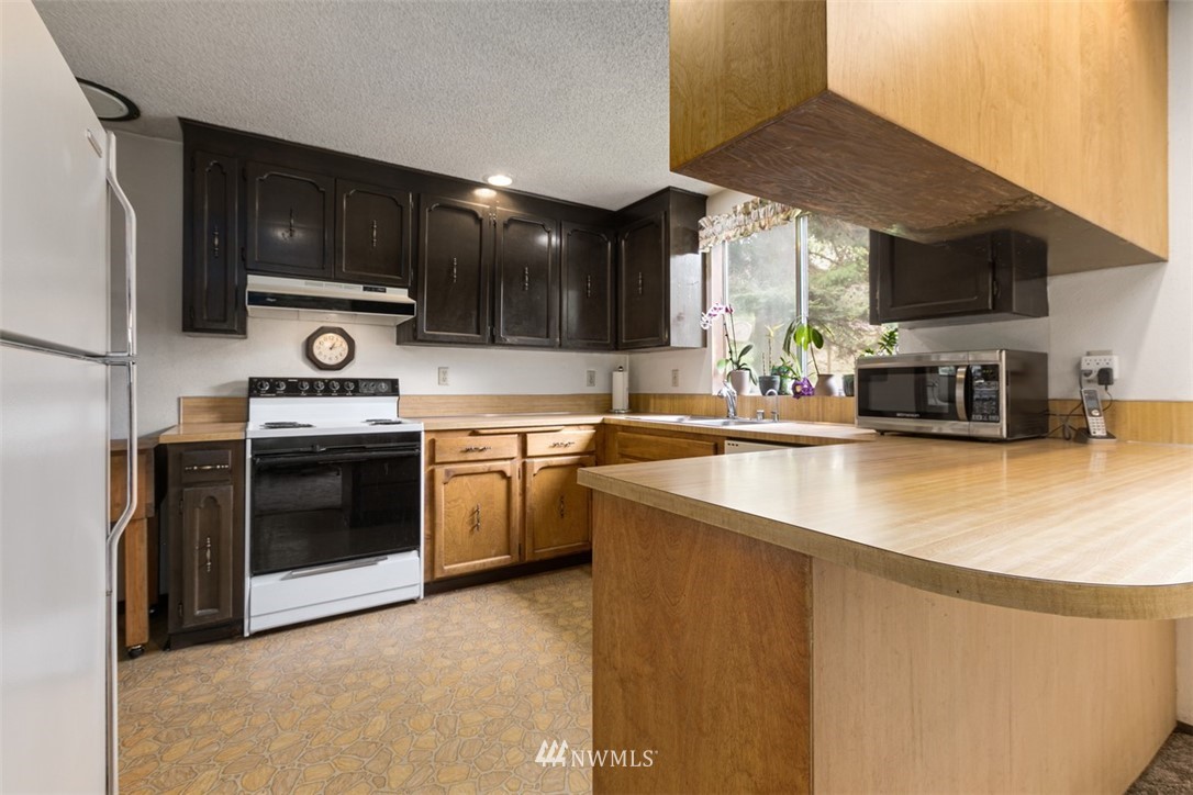 23525 27th Avenue Southeast Bothell, WA 98021 - Photo 7 of 40 a kitchen with stainless steel appliances granite countertop a stove a sink and a microwave