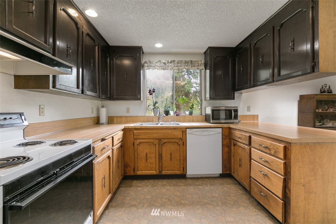 23525 27th Avenue Southeast Bothell, WA 98021 - Photo 9 of 40 a kitchen with stainless steel appliances granite countertop a sink stove and refrigerator