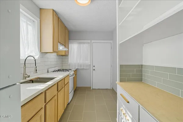 a kitchen with a sink stove and cabinets