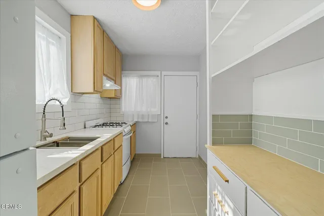 a kitchen with a sink stove and cabinets