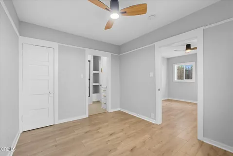 an empty room with closet and a ceiling fan