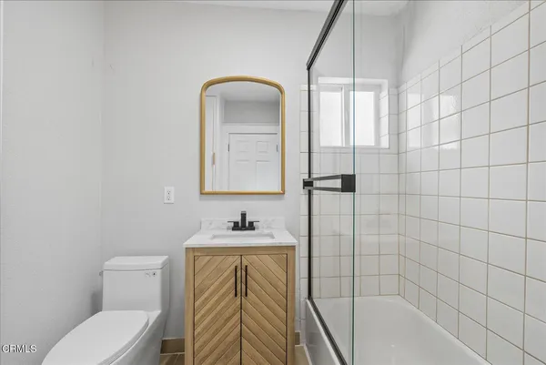 a bathroom with a toilet sink vanity tub and shower