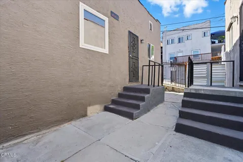 a view of staircase with lots of frames on wall and a potted plant