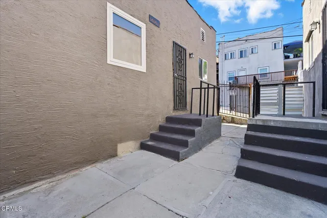 a view of staircase with lots of frames on wall and a potted plant