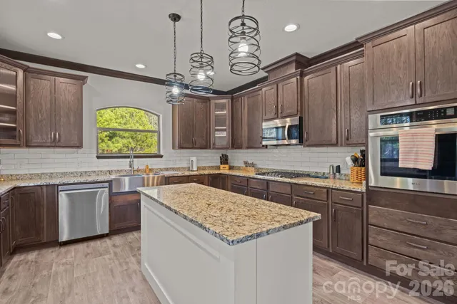 a kitchen with kitchen island granite countertop a stove cabinets and oven