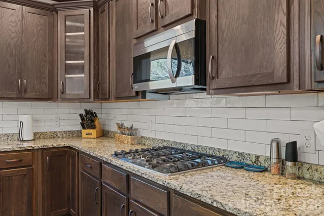 a kitchen with granite countertop a sink a stove and cabinets