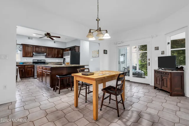 a view of a dining room with furniture a chandelier and kitchen view