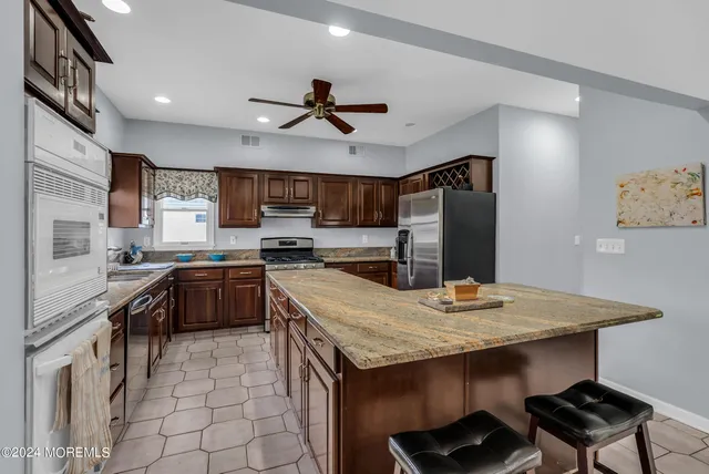 a kitchen with granite countertop a sink appliances and cabinets