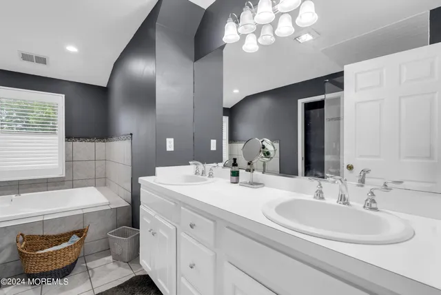 a bathroom with a double vanity sink a toilet and a large mirror