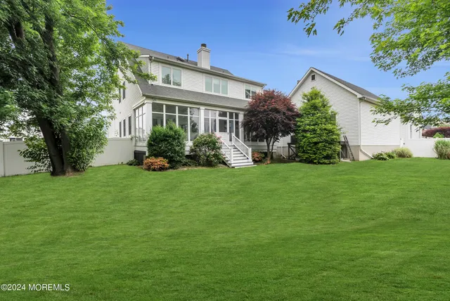 a front view of a house with a yard and trees