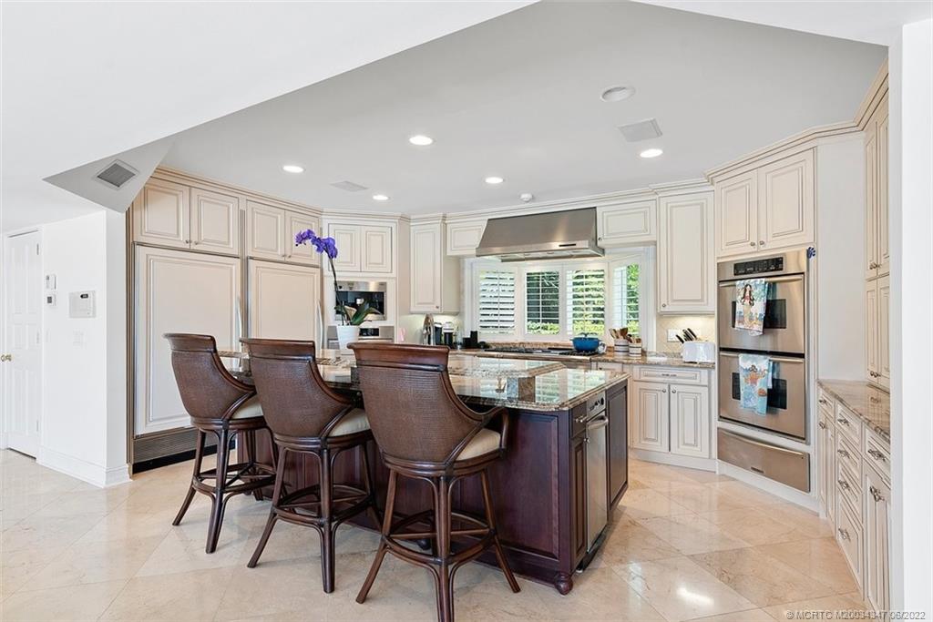 2421 Bahia Way Stuart, FL 34996 - Photo 11 of 83 a kitchen with stainless steel appliances granite countertop a table chairs and a refrigerator