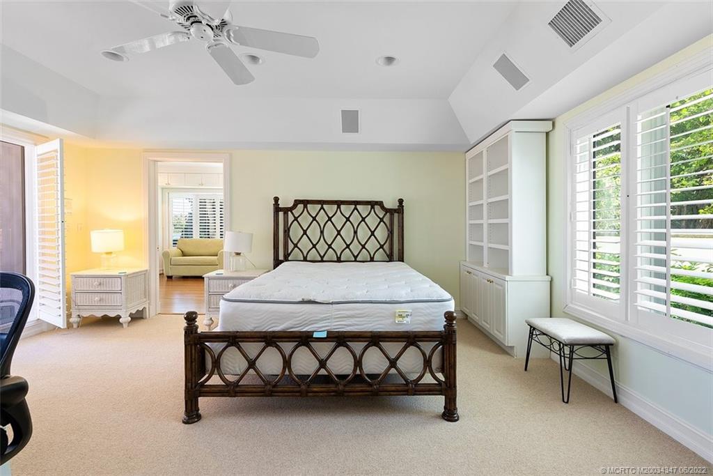2421 Bahia Way Stuart, FL 34996 - Photo 23 of 83 a bedroom with a bed and a chandelier