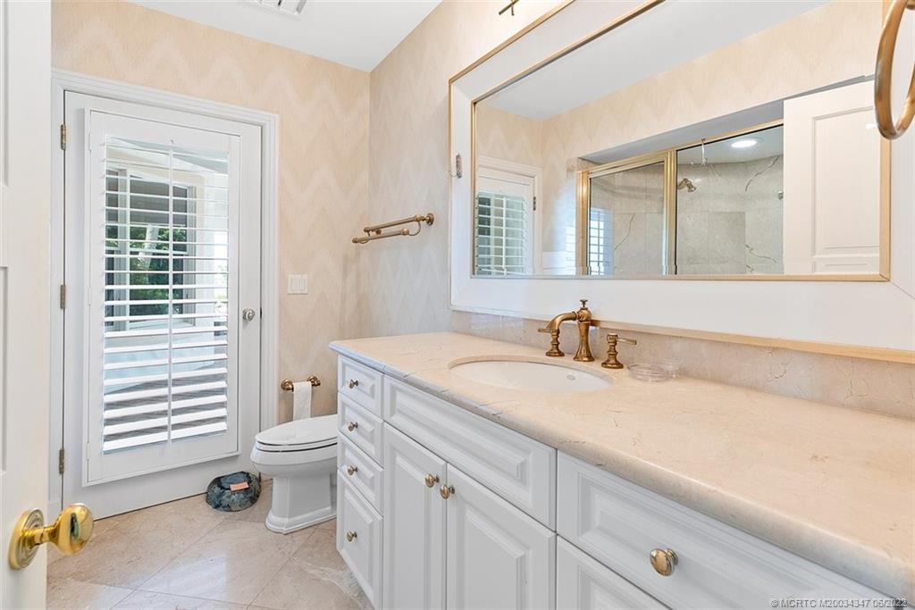 2421 Bahia Way Stuart, FL 34996 - Photo 25 of 83 a bathroom with a granite countertop sink mirror vanity and toilet