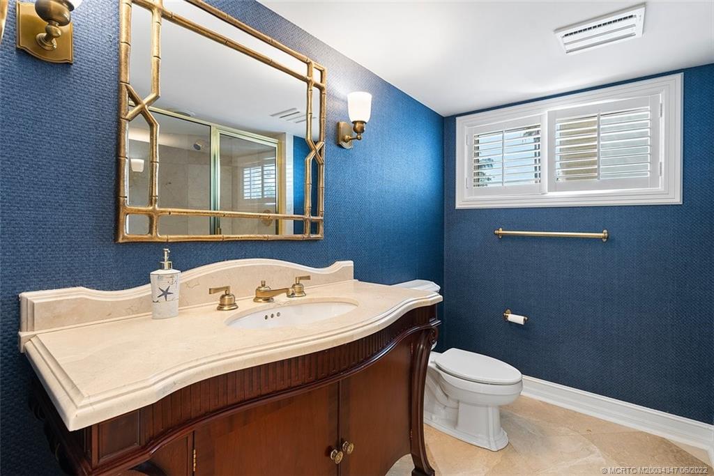 2421 Bahia Way Stuart, FL 34996 - Photo 26 of 83 a bathroom with a sink a toilet and mirror
