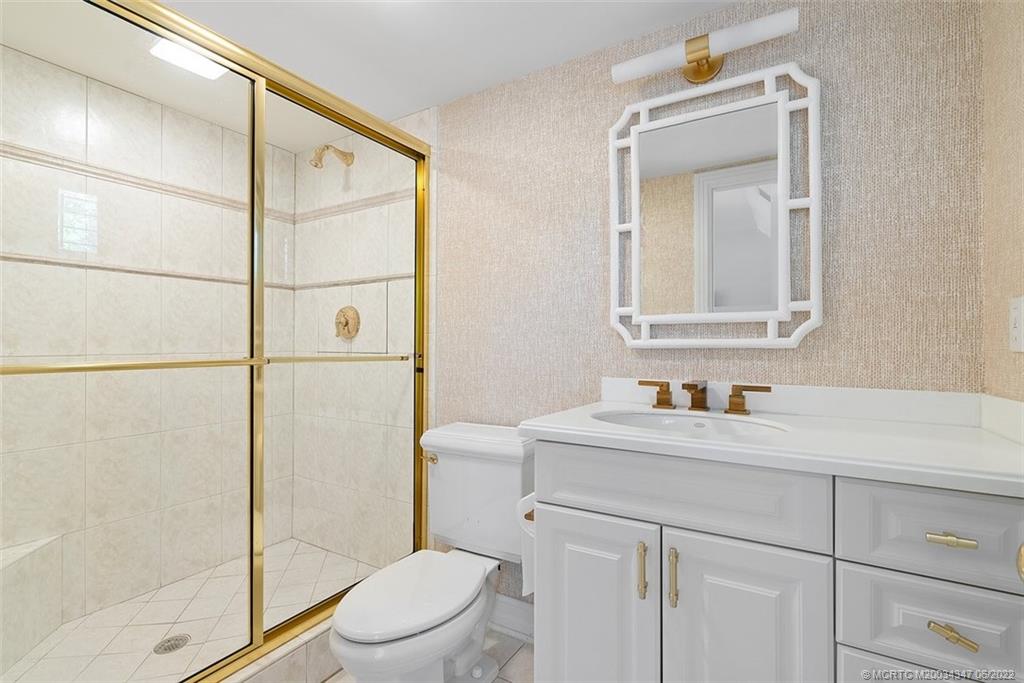2421 Bahia Way Stuart, FL 34996 - Photo 29 of 83 a bathroom with a toilet sink vanity and mirror
