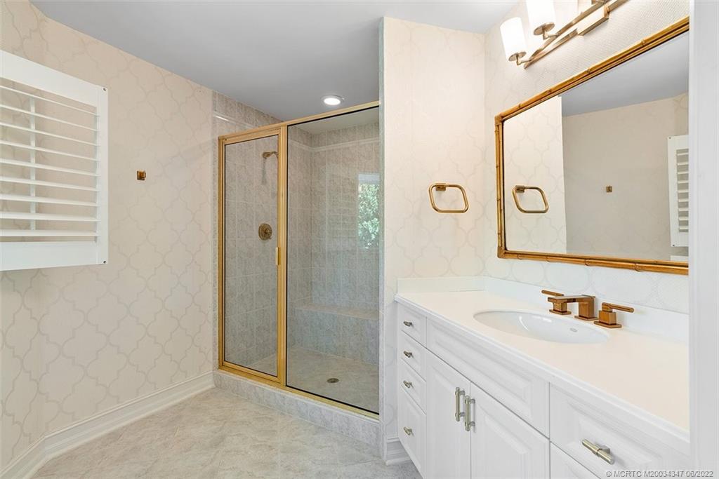 2421 Bahia Way Stuart, FL 34996 - Photo 30 of 83 a bathroom with a shower sink and mirror