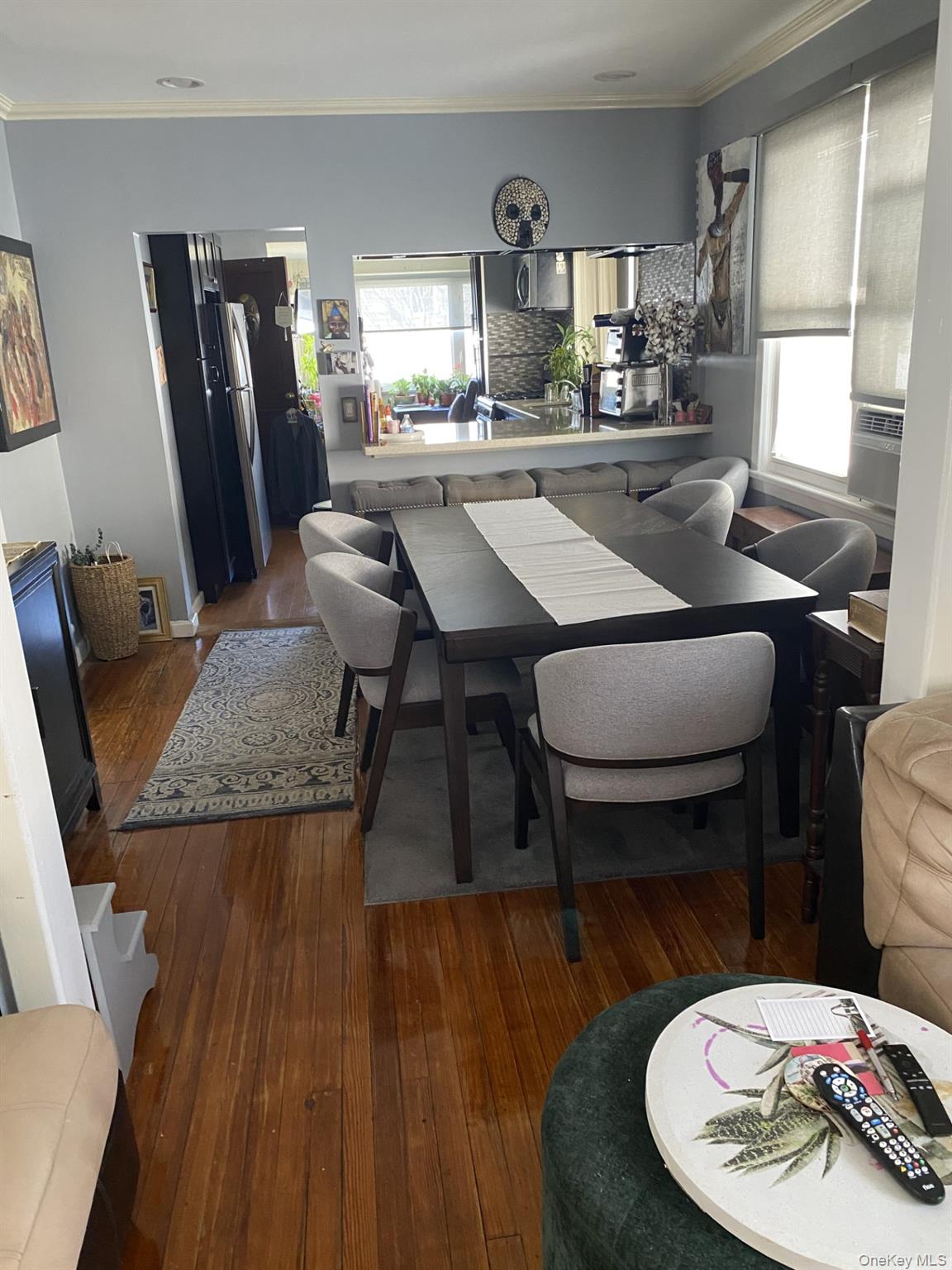 145-24 223rd Street Queens, NY 11413 - Photo 3 of 16 a kitchen with a table chairs refrigerator and microwave