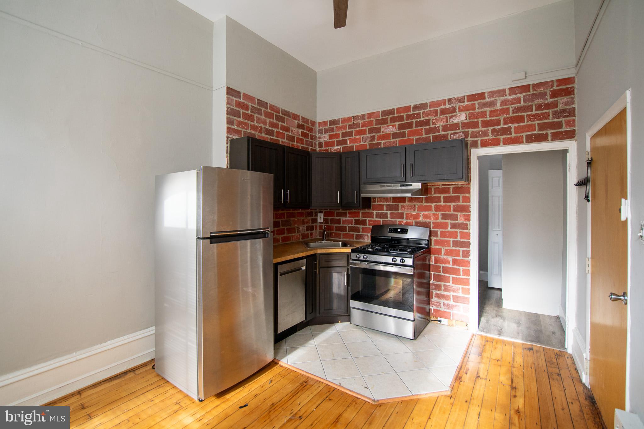 1919 Spring Garden Street, Unit 1F Philadelphia, PA 19130 - Photo 1 of 9 a kitchen with stainless steel appliances granite countertop a refrigerator a stove and a sink