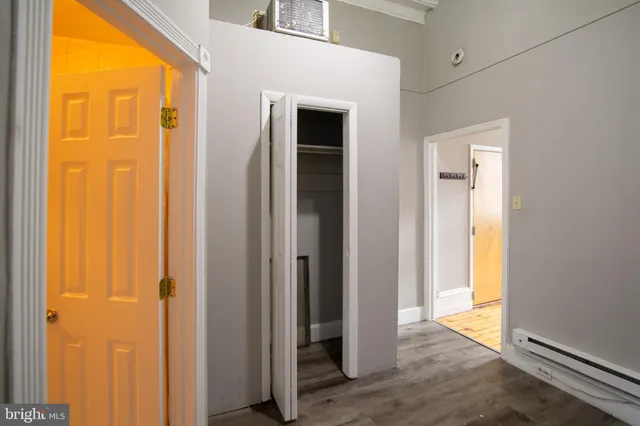 a view of a hallway with wooden floor and closet