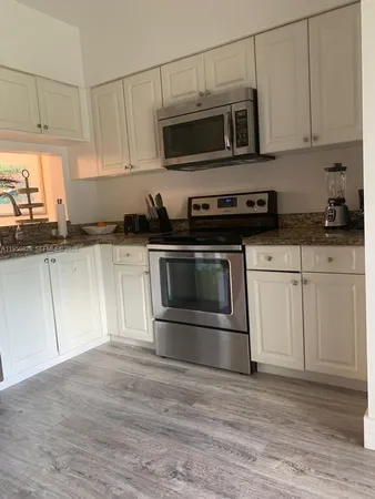 a kitchen with stainless steel appliances granite countertop a stove microwave and cabinets