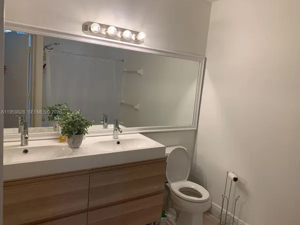 a bathroom with a sink mirror vanity and toilet
