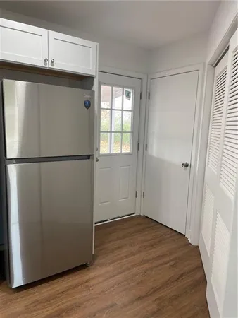 a view of a refrigerator in kitchen and wooden floor