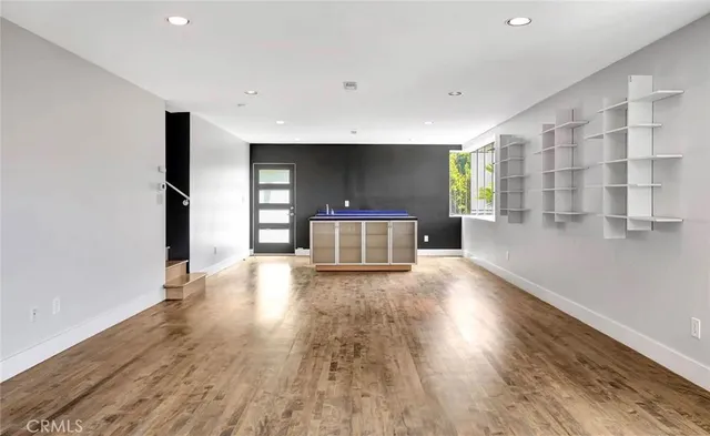 a view of a living room with wooden floor and a cabinet
