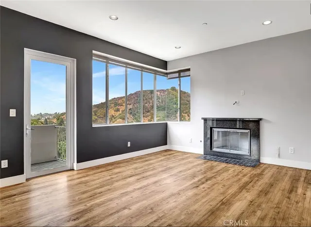 a view of an empty room with a window and fire place