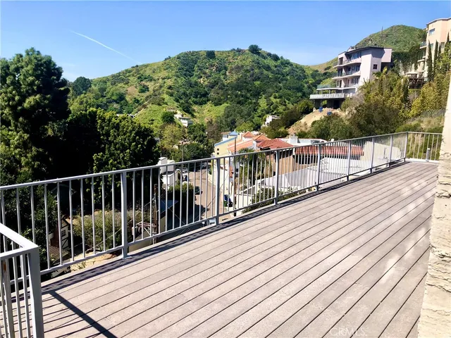 a view of balcony with wooden floor and fence