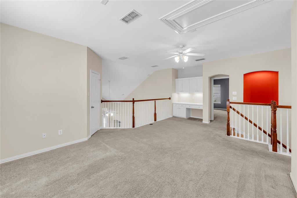 3920 Autumn Lane Bedford, TX 76021 - Photo 26 of 36 Spacious second-level area featuring light-toned carpeting, a built-in desk with upper cabinetry, and a ceiling fan