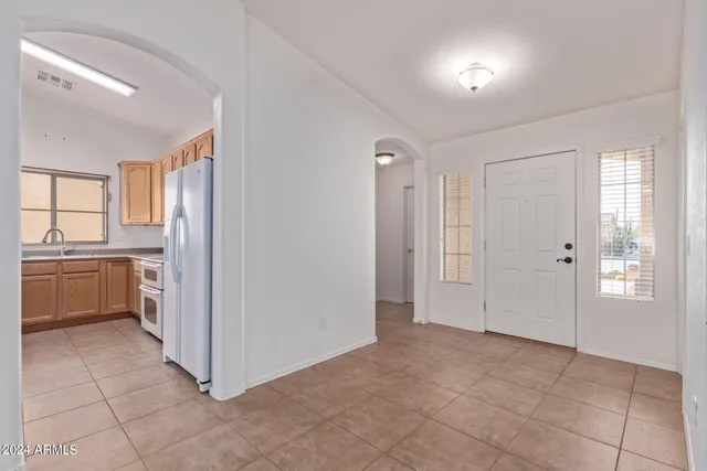 a view of a kitchen with a sink and dishwasher a refrigerator with white cabinets