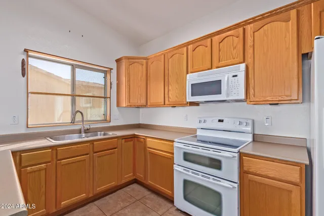 a kitchen with cabinets appliances a sink and a window