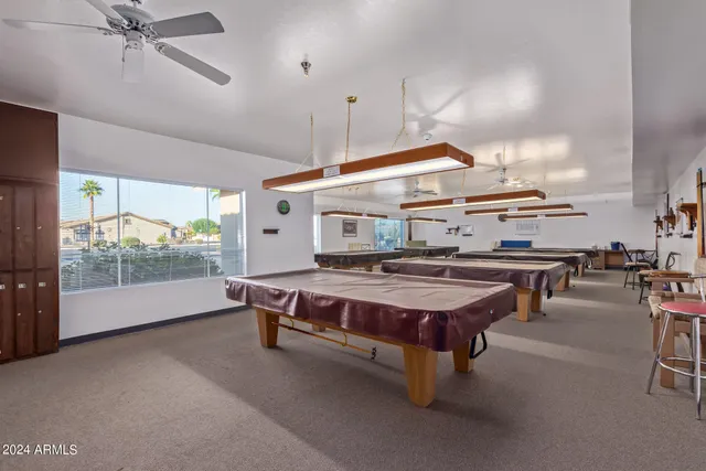 a living room with a table tennis pool table and chairs